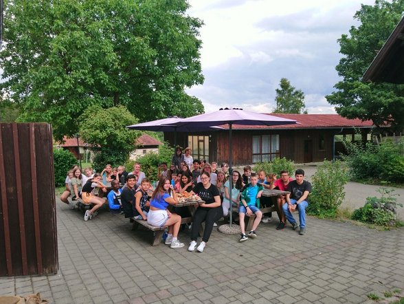 Bild einer Schulklasse im Freien auf Bänken sitzend