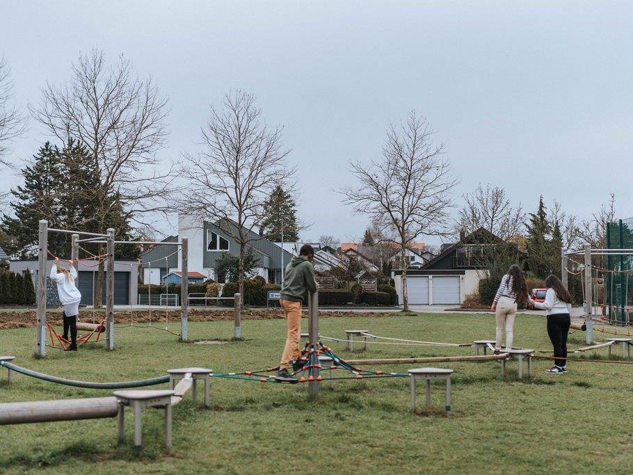 Kinder an Spielgeräten im Freien.